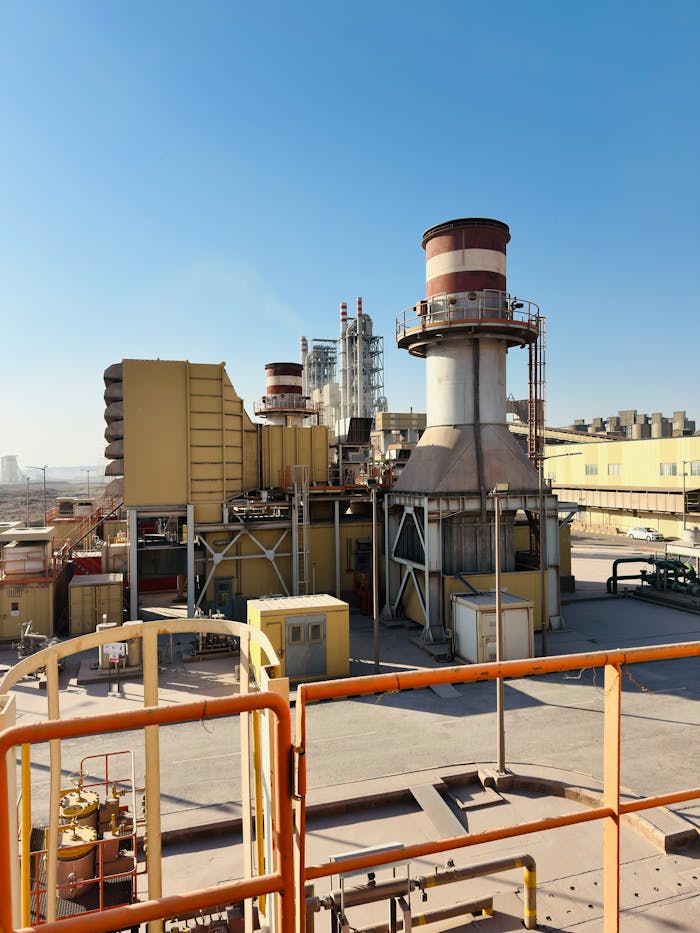 A Saudi Arabian power plant under a clear blue sky, featuring turbines and industrial equipment.
